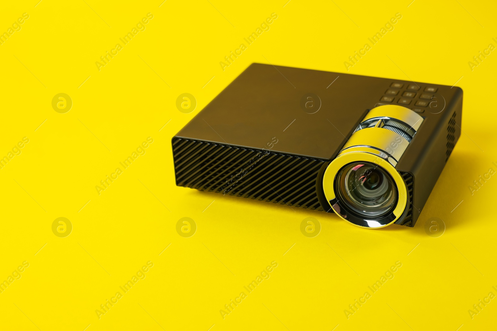 Modern video projector on yellow background, space for text Photo of Modern video projector on yellow background, space for text