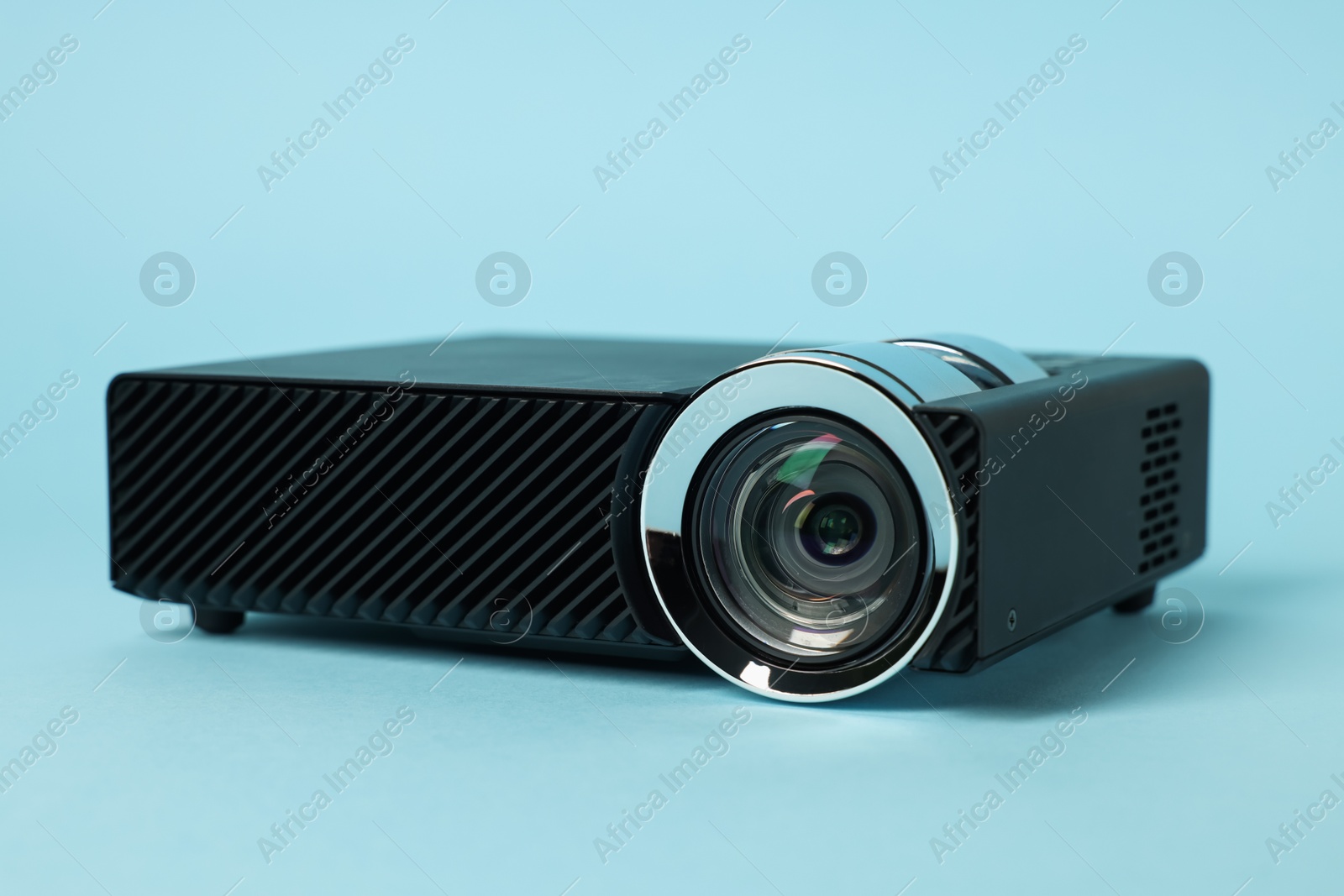 Modern video projector on light blue background, closeup Photo of Modern video projector on light blue background, closeup