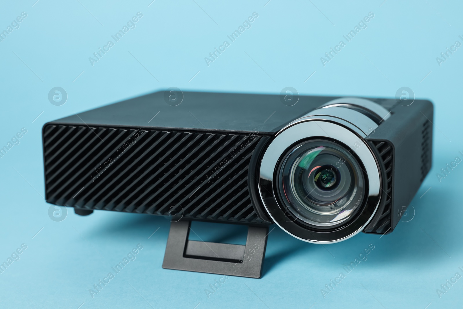 Modern video projector on light blue background, closeup Photo of Modern video projector on light blue background, closeup