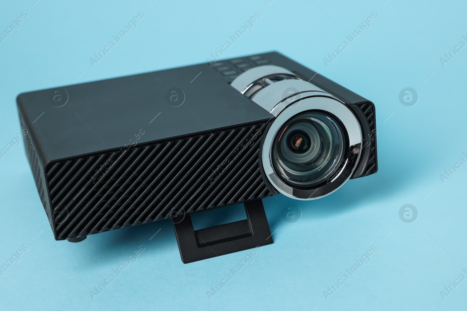 Modern video projector on light blue background, closeup Photo of Modern video projector on light blue background, closeup