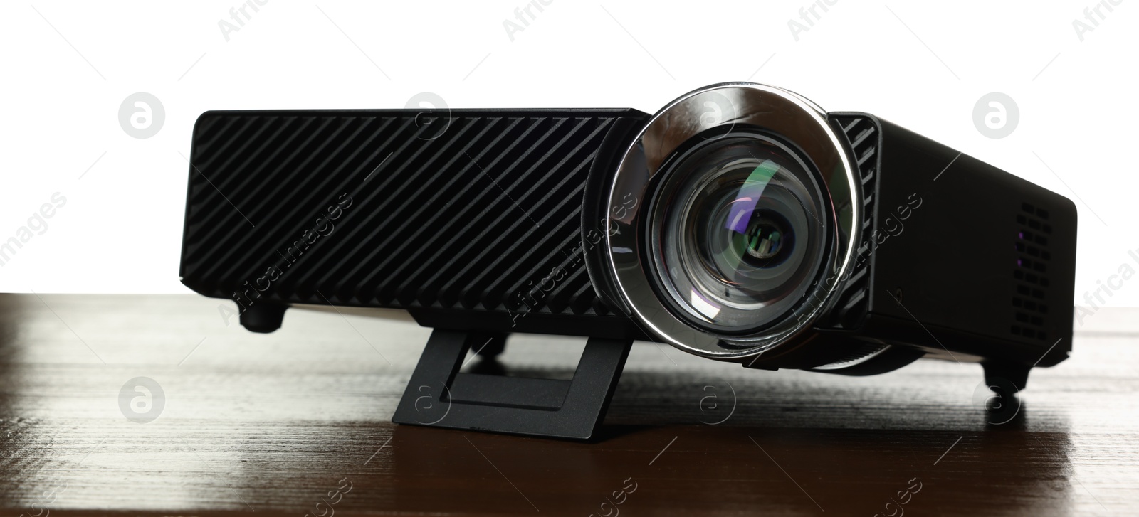 Modern video projector on wooden table against white background Photo of Modern video projector on wooden table against white background
