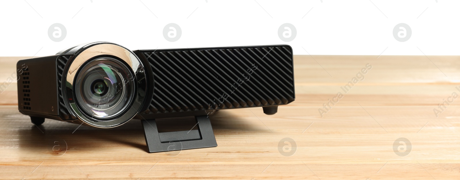 Modern video projector on wooden table against white background Photo of Modern video projector on wooden table against white background