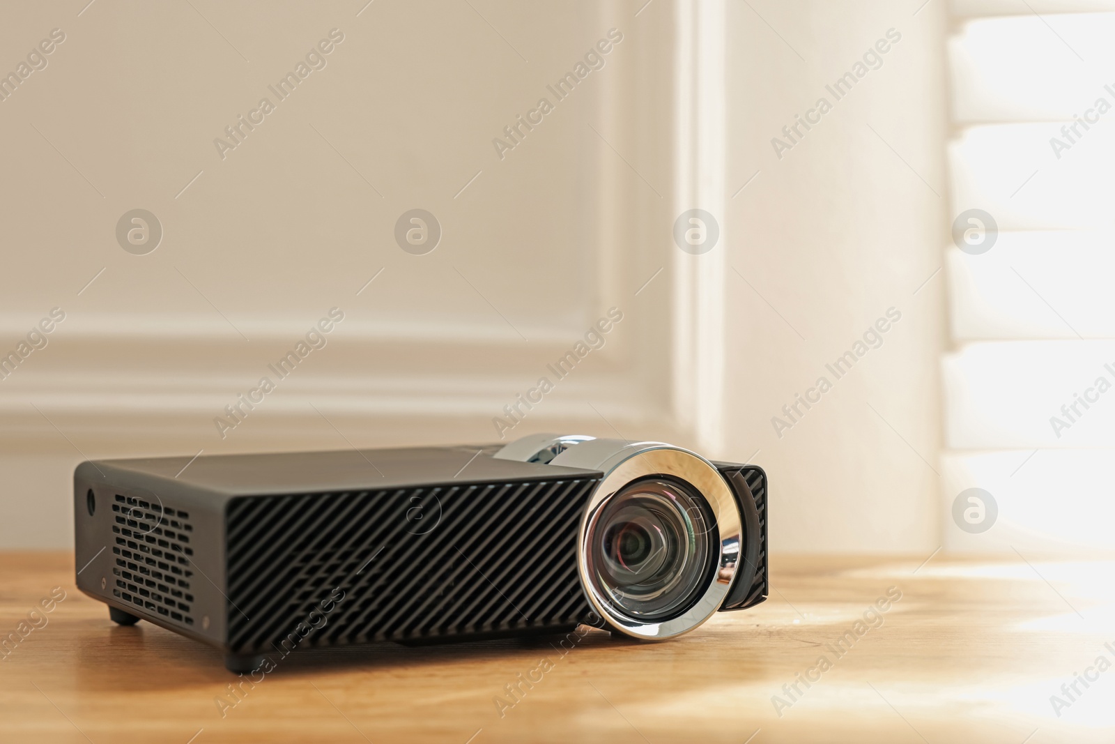 Modern video projector on wooden table indoors, closeup. Space for text Photo of Modern video projector on wooden table indoors, closeup. Space for text
