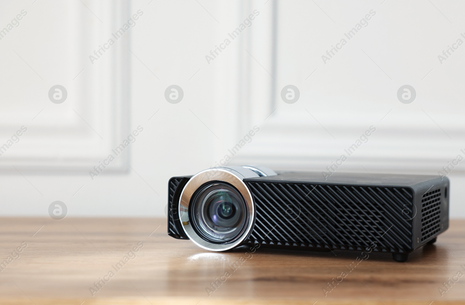 Modern video projector on wooden table indoors, closeup. Space for text Photo of Modern video projector on wooden table indoors, closeup. Space for text