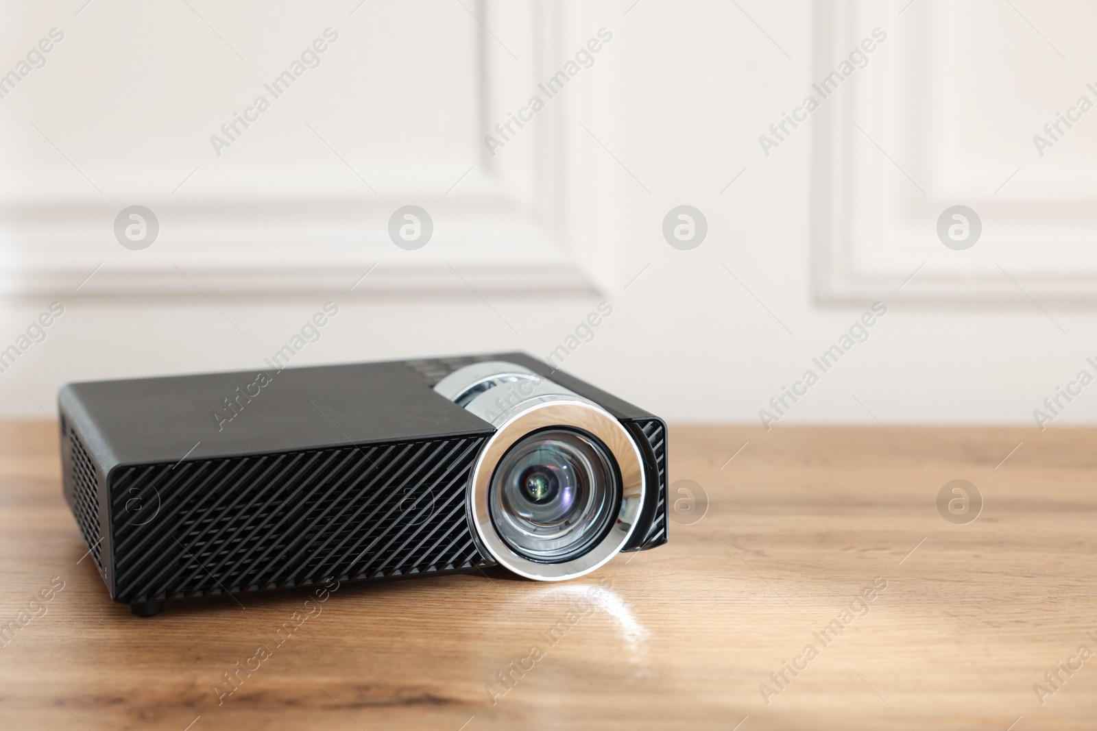 Modern video projector on wooden table indoors, closeup. Space for text Photo of Modern video projector on wooden table indoors, closeup. Space for text