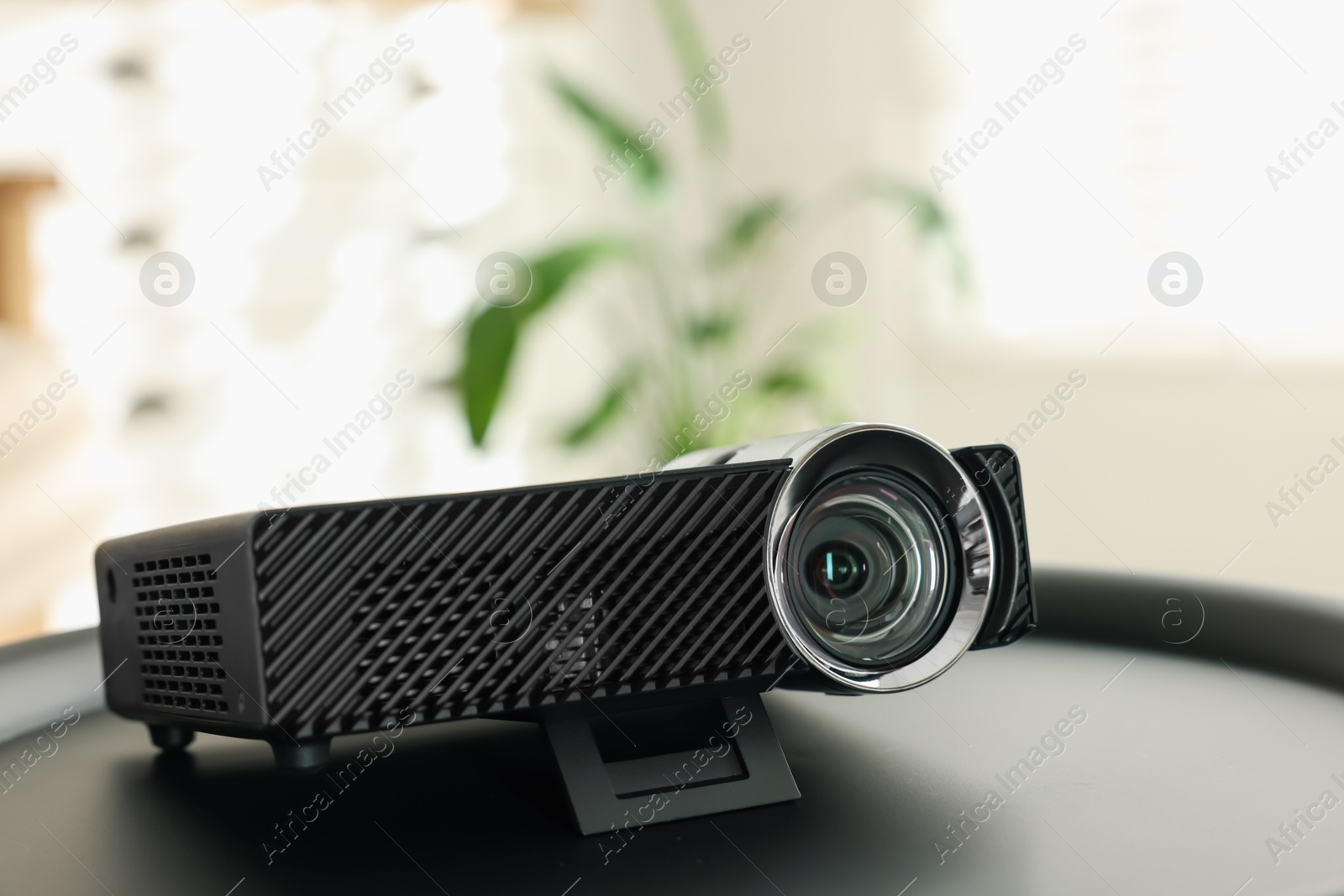 Modern video projector on black table indoors, closeup Photo of Modern video projector on black table indoors, closeup