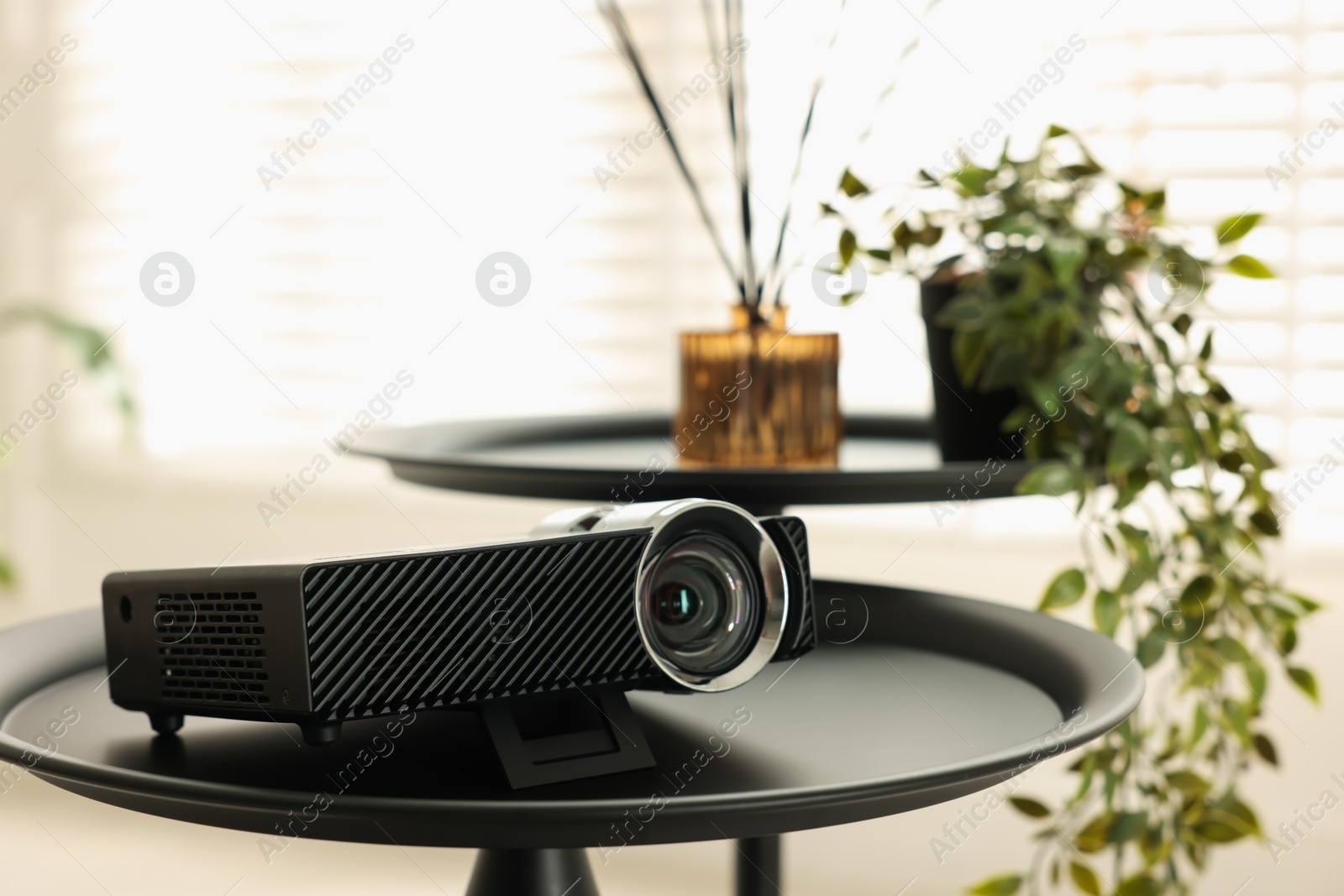 Modern video projector on black table indoors Photo of Modern video projector on black table indoors
