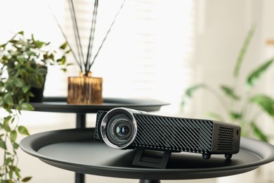 Photo of Modern video projector on black table indoors