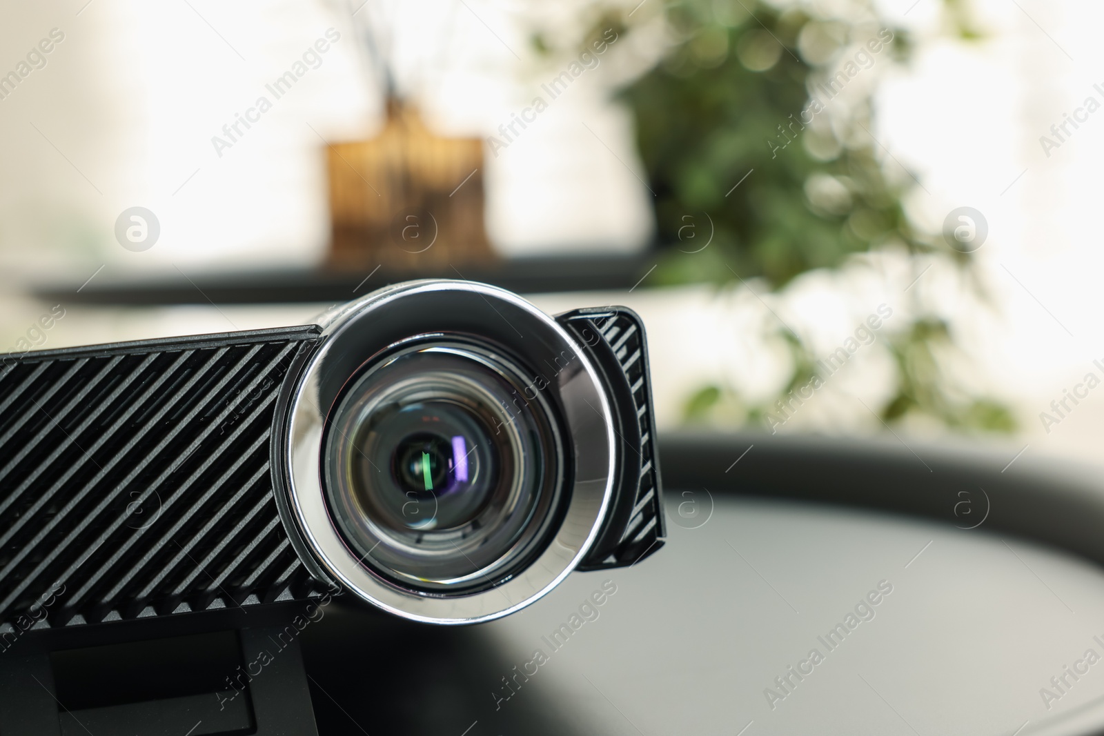 Modern video projector on black table indoors, closeup Photo of Modern video projector on black table indoors, closeup