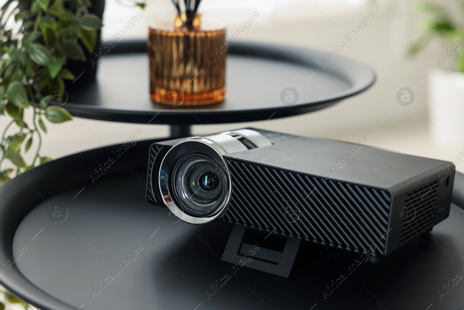 Modern video projector on black table indoors, closeup Photo of Modern video projector on black table indoors, closeup