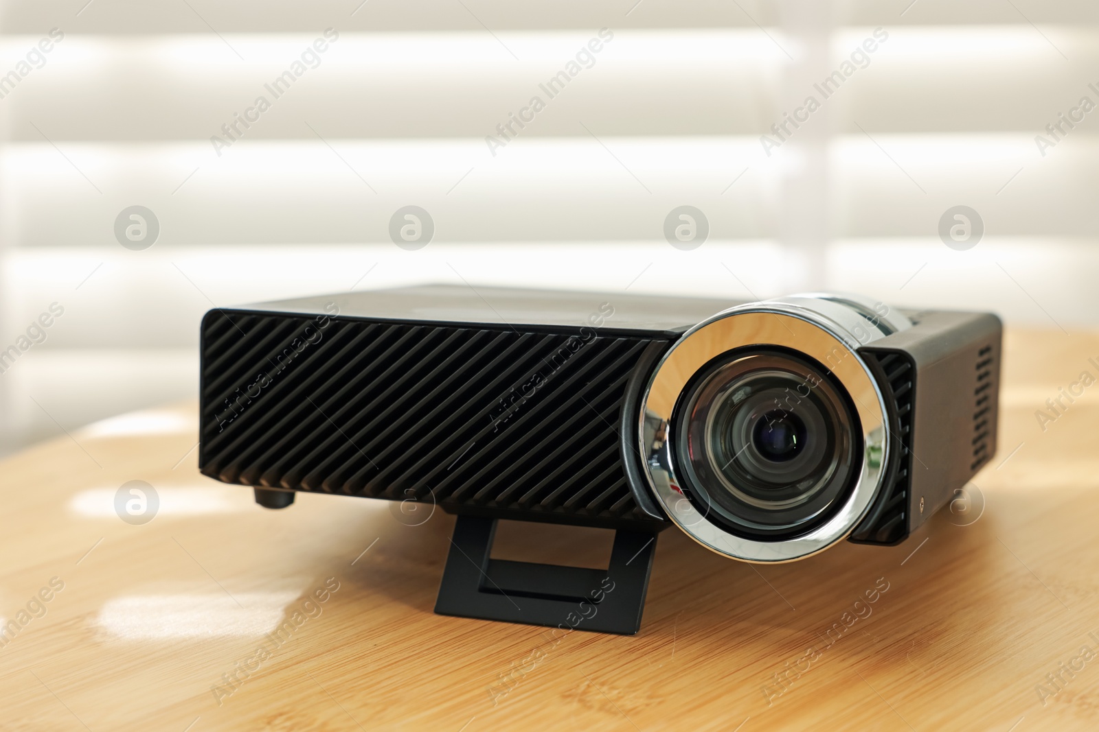 Modern video projector on wooden table indoors, closeup Photo of Modern video projector on wooden table indoors, closeup