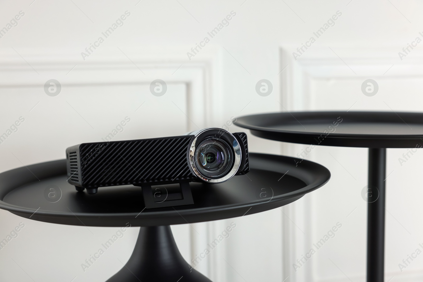 Modern video projector on black table indoors Photo of Modern video projector on black table indoors