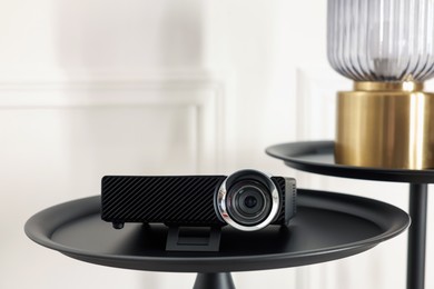 Photo of Modern video projector on black table indoors