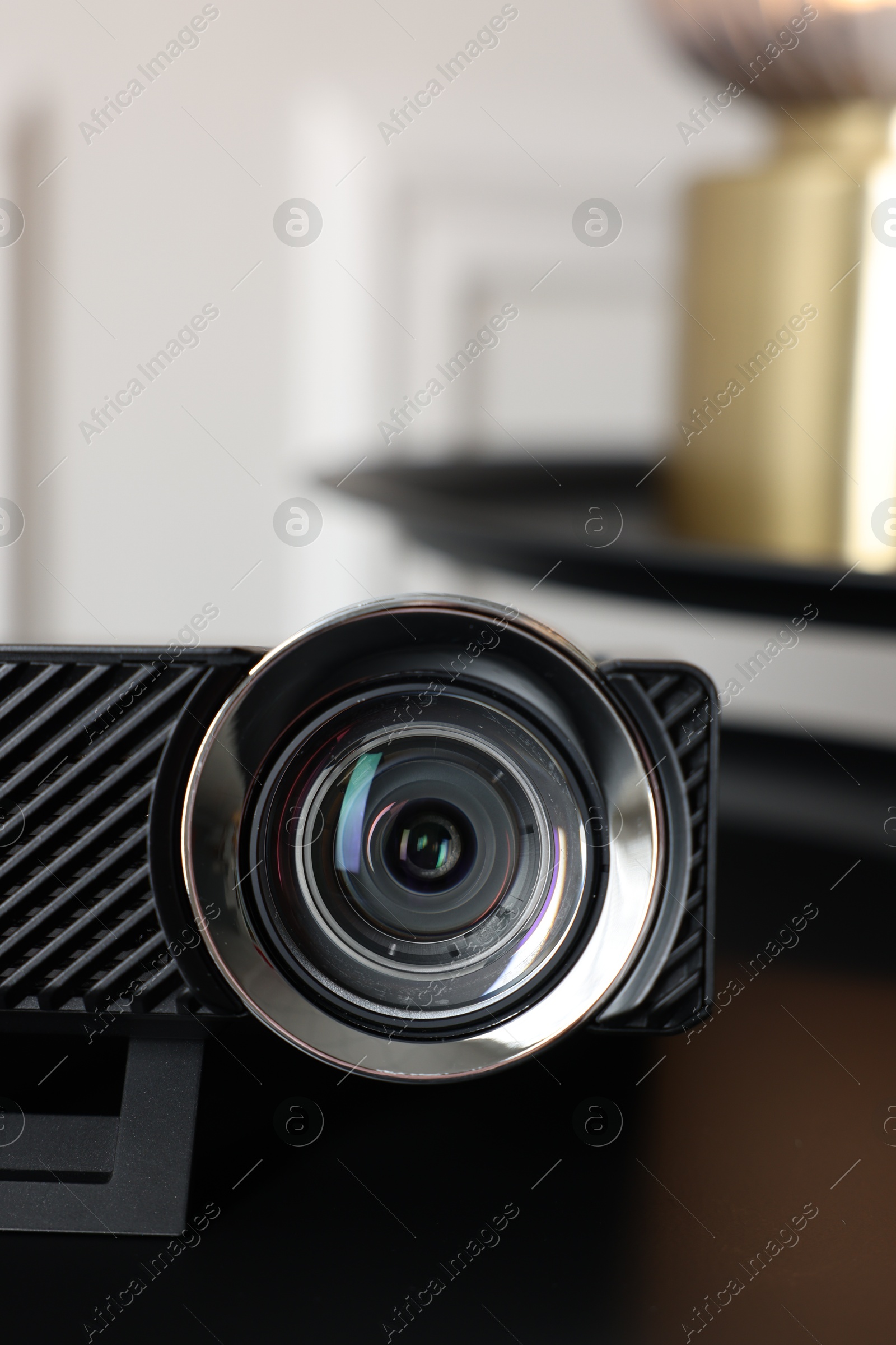 Modern video projector on black table indoors, closeup Photo of Modern video projector on black table indoors, closeup