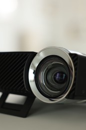 Photo of Modern video projector on white table indoors, closeup
