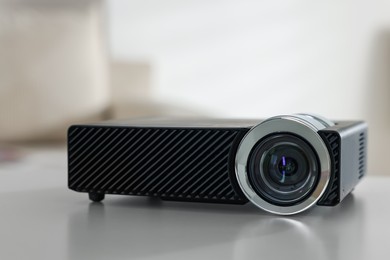 Photo of Modern video projector on white table indoors, closeup