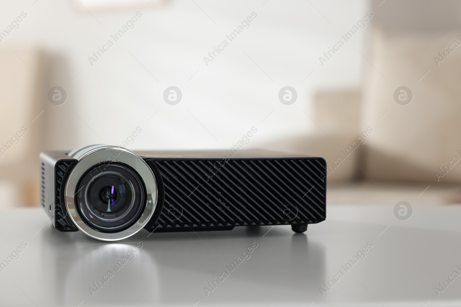 Modern video projector on white table indoors, closeup Photo of Modern video projector on white table indoors, closeup