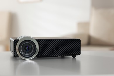 Photo of Modern video projector on white table indoors, closeup