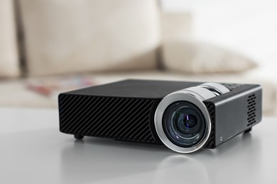 Photo of Modern video projector on white table indoors, closeup