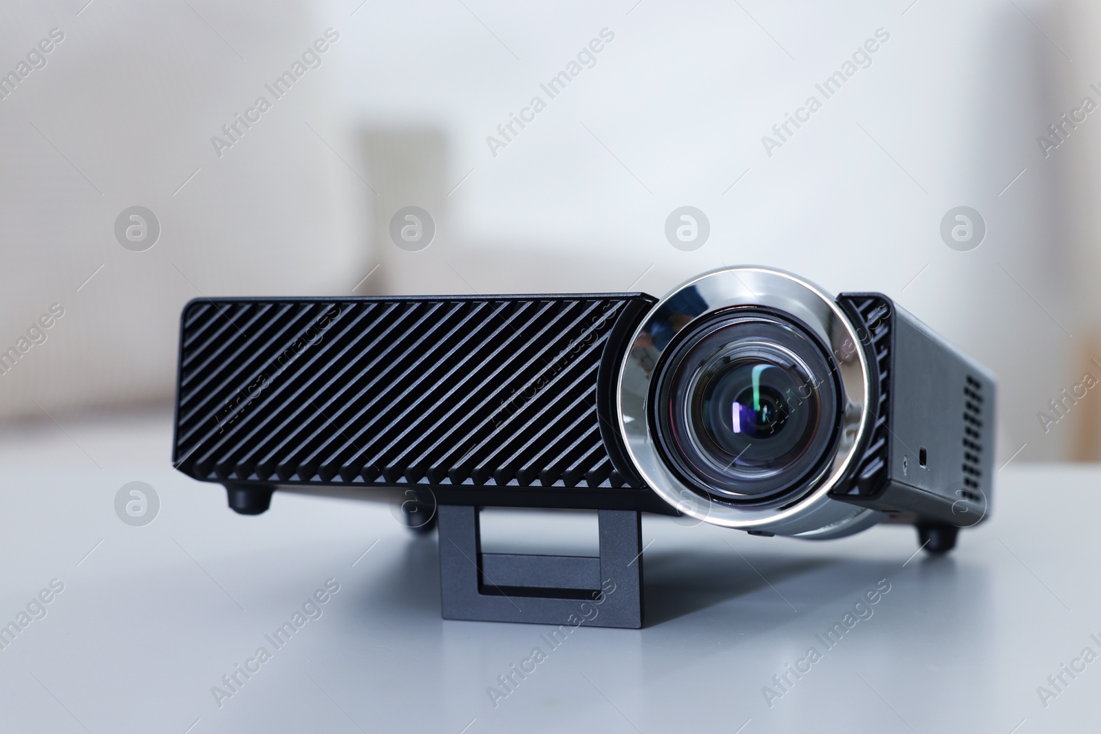 Modern video projector on white table indoors, closeup Photo of Modern video projector on white table indoors, closeup