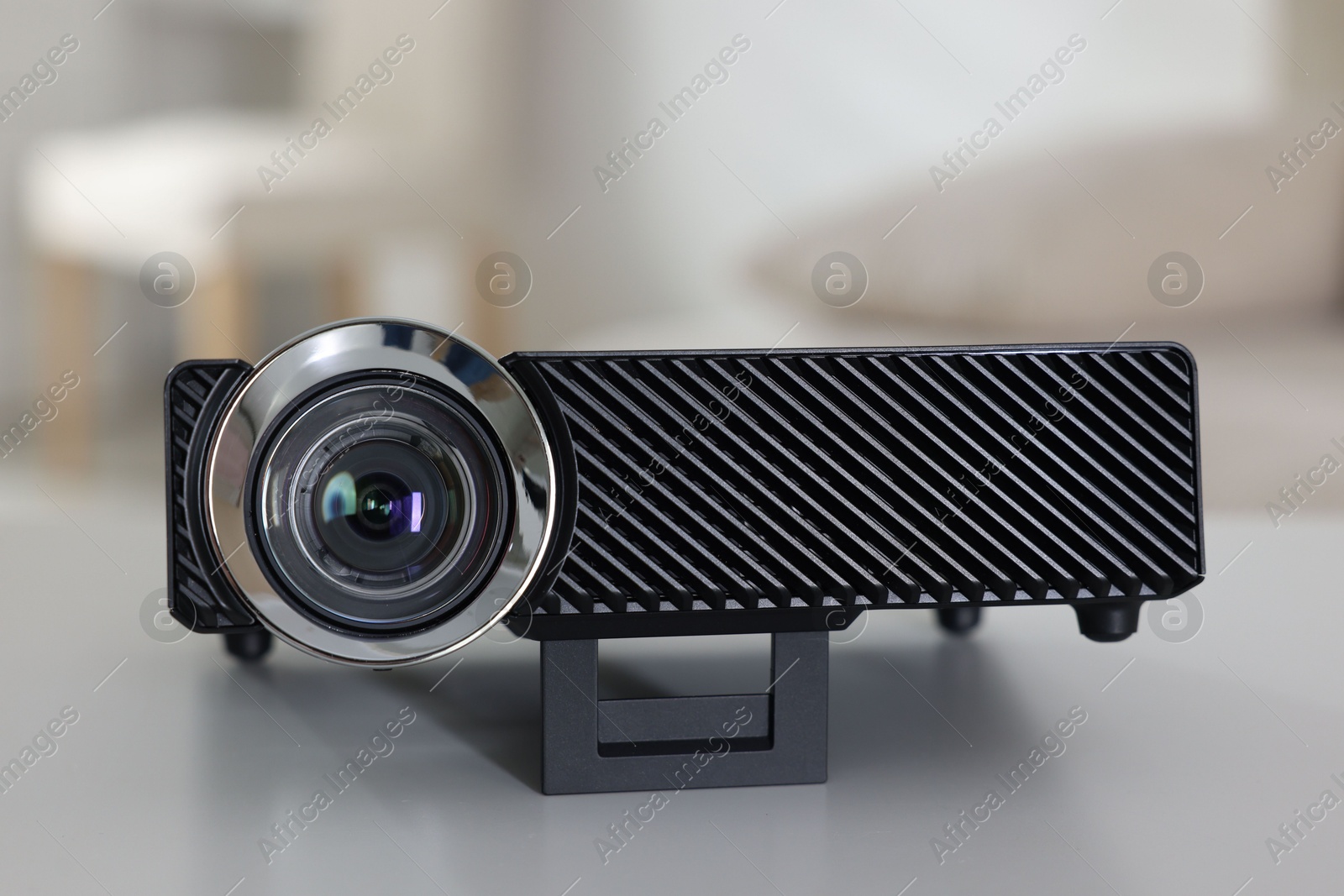Photo of Modern video projector on white table indoors, closeup