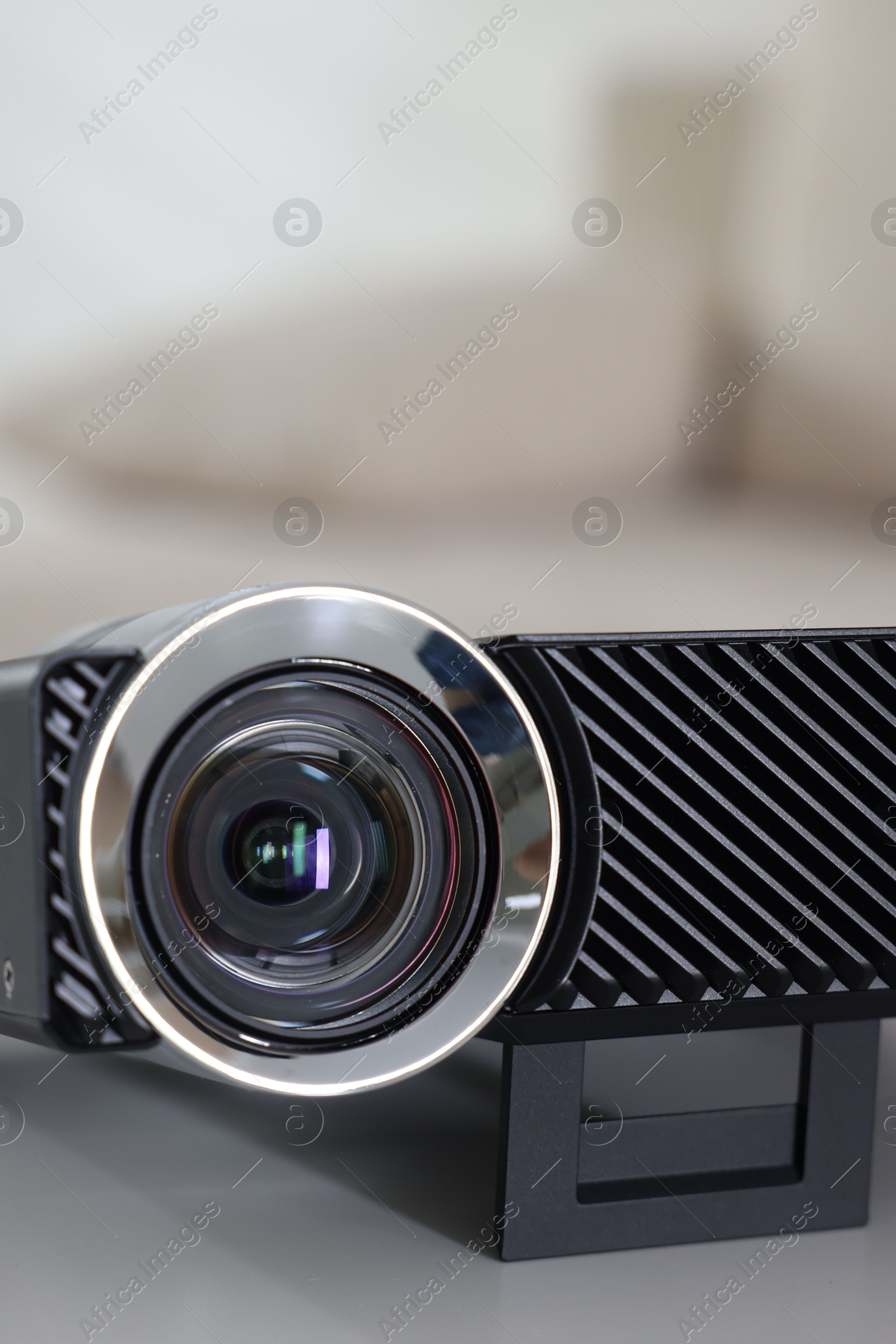 Photo of Modern video projector on white table indoors, closeup