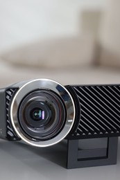 Photo of Modern video projector on white table indoors, closeup