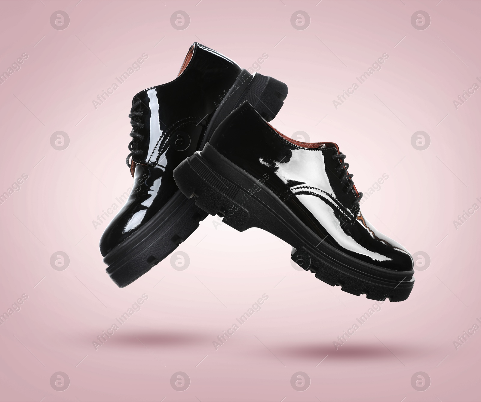 Stylish black shoes in air on dusty pink gradient background Image of Stylish black shoes in air on dusty pink gradient background