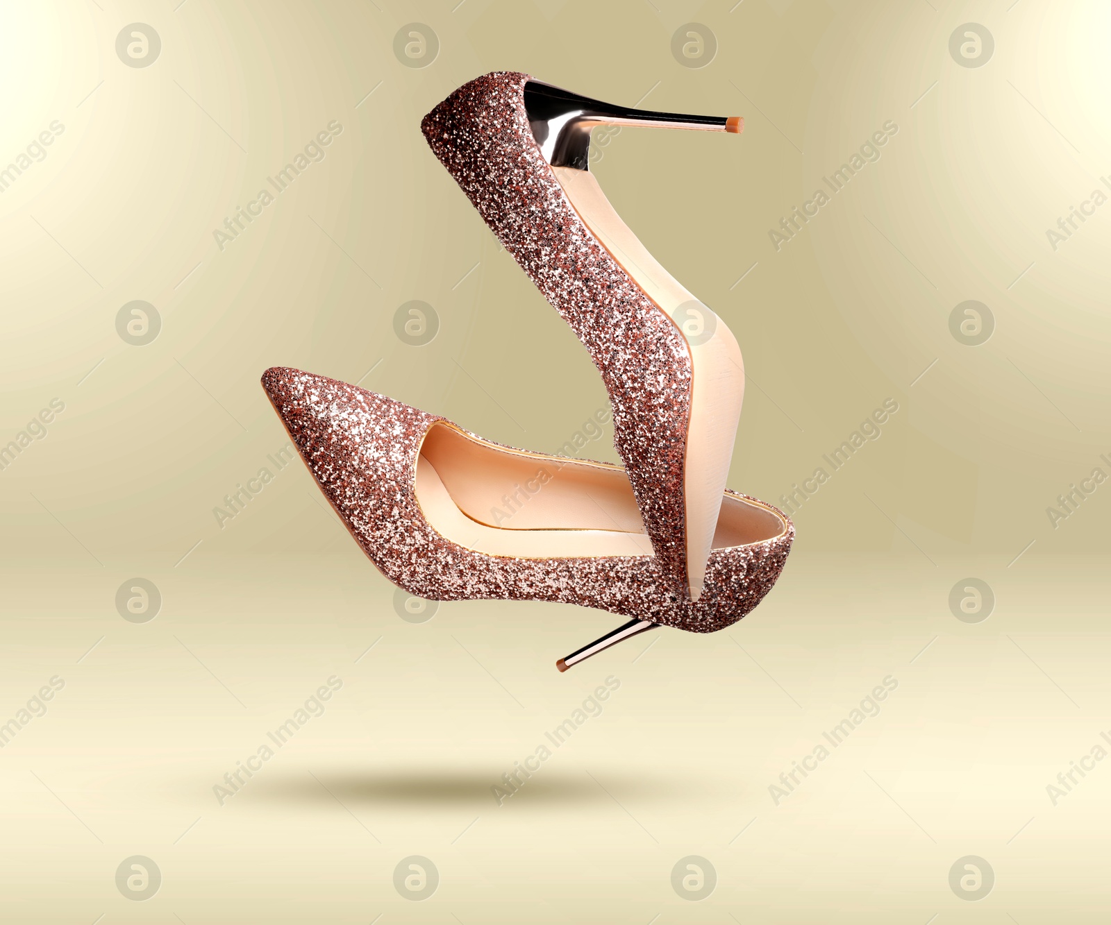 Stylish sparkly high heel shoes in air on beige gradient background Image of Stylish sparkly high heel shoes in air on beige gradient background