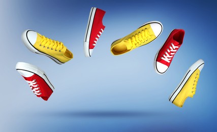 Image of Different stylish sneakers in air on blue gradient background