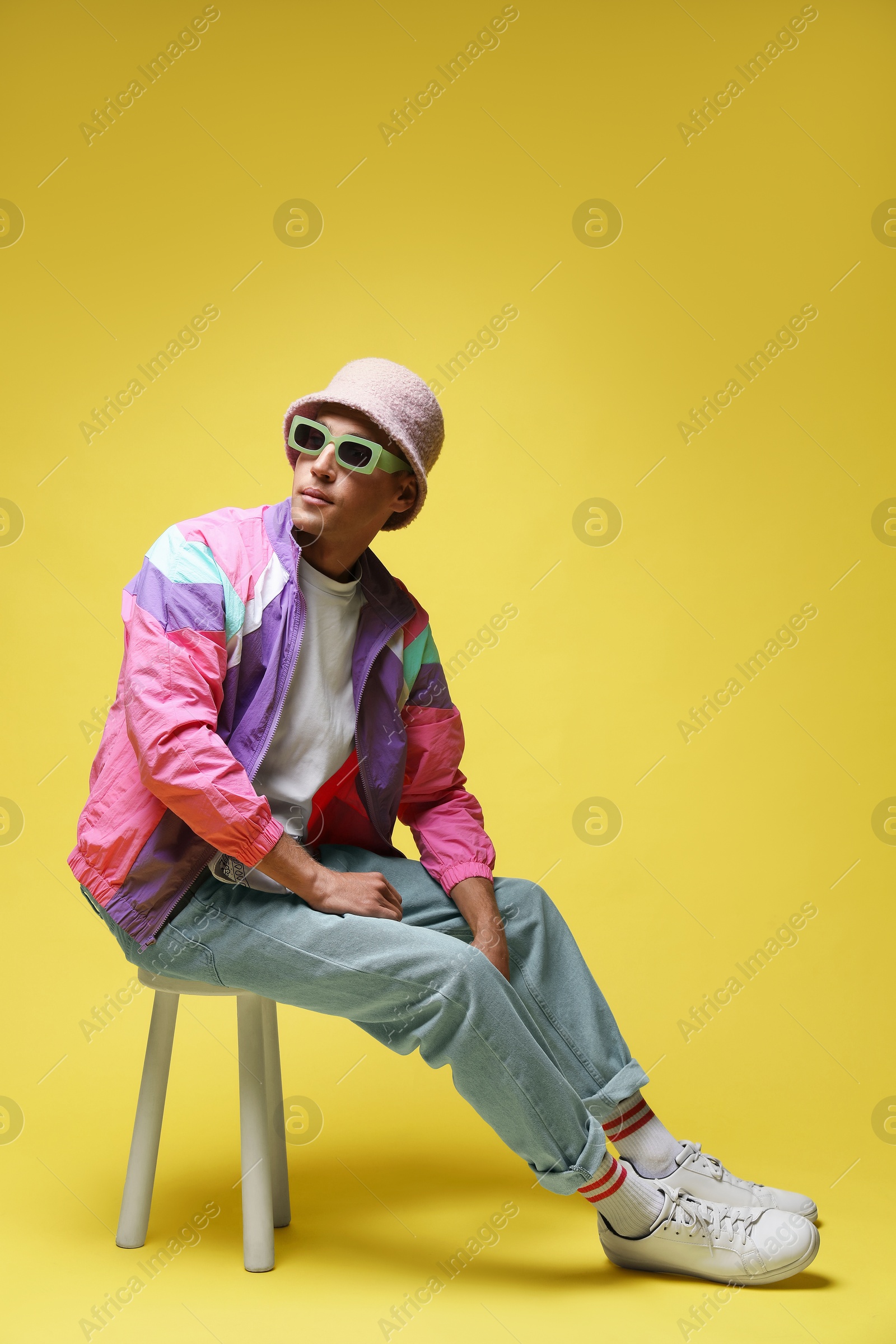Fashionable portrait of handsome man in stylish outfit on yellow background Photo of Fashionable portrait of handsome man in stylish outfit on yellow background