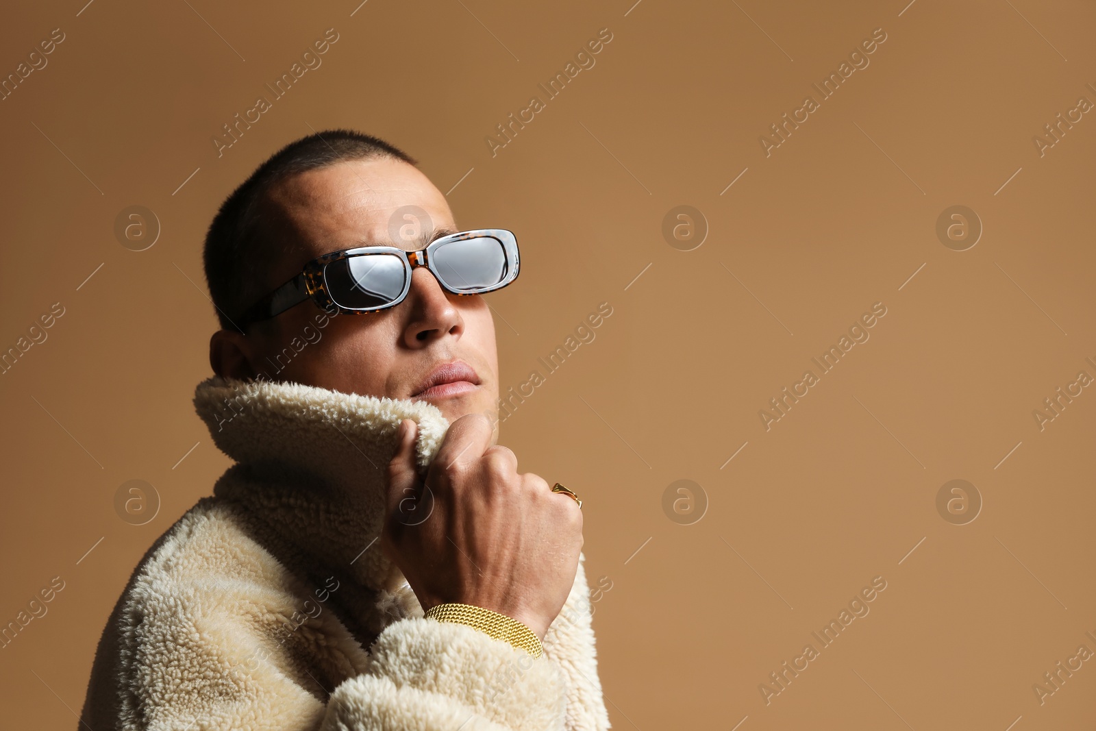 Fashionable portrait of handsome man in stylish outfit on brown background, space for text Photo of Fashionable portrait of handsome man in stylish outfit on brown background, space for text