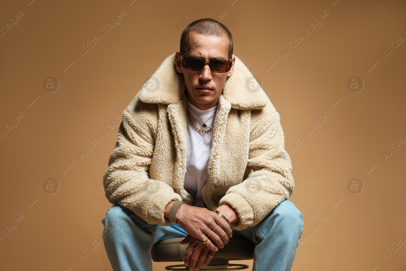 Fashionable portrait of handsome man in stylish outfit on brown background Photo of Fashionable portrait of handsome man in stylish outfit on brown background