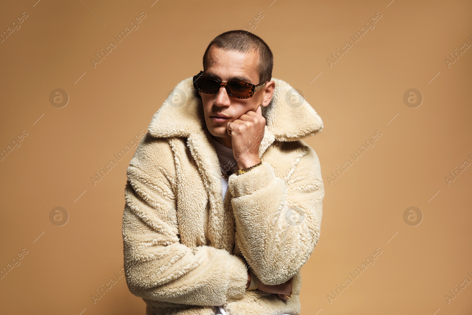 Fashionable portrait of handsome man in stylish outfit on brown background Photo of Fashionable portrait of handsome man in stylish outfit on brown background