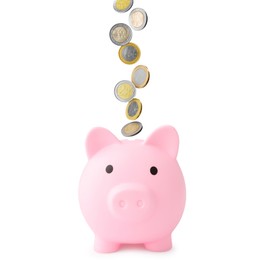 Image of Coins falling into pink piggy bank on white background