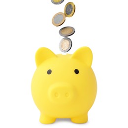 Image of Coins falling into yellow piggy bank on white background