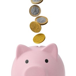 Image of Coins falling into pink piggy bank on white background