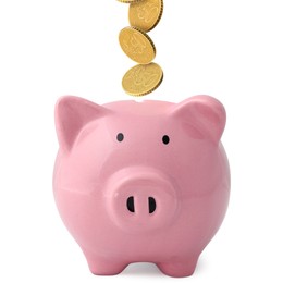 Image of Coins falling into pink piggy bank on white background