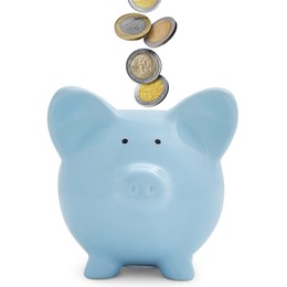 Image of Coins falling into light blue piggy bank on white background