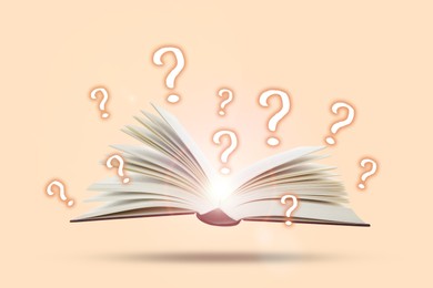 Image of Question marks above open book in air against pink beige background