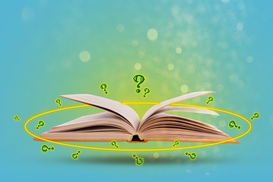 Image of Question marks and magic lights around open book in air against light blue background