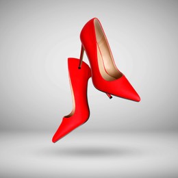 Image of Fashionable red high heel shoes in air on grey gradient background