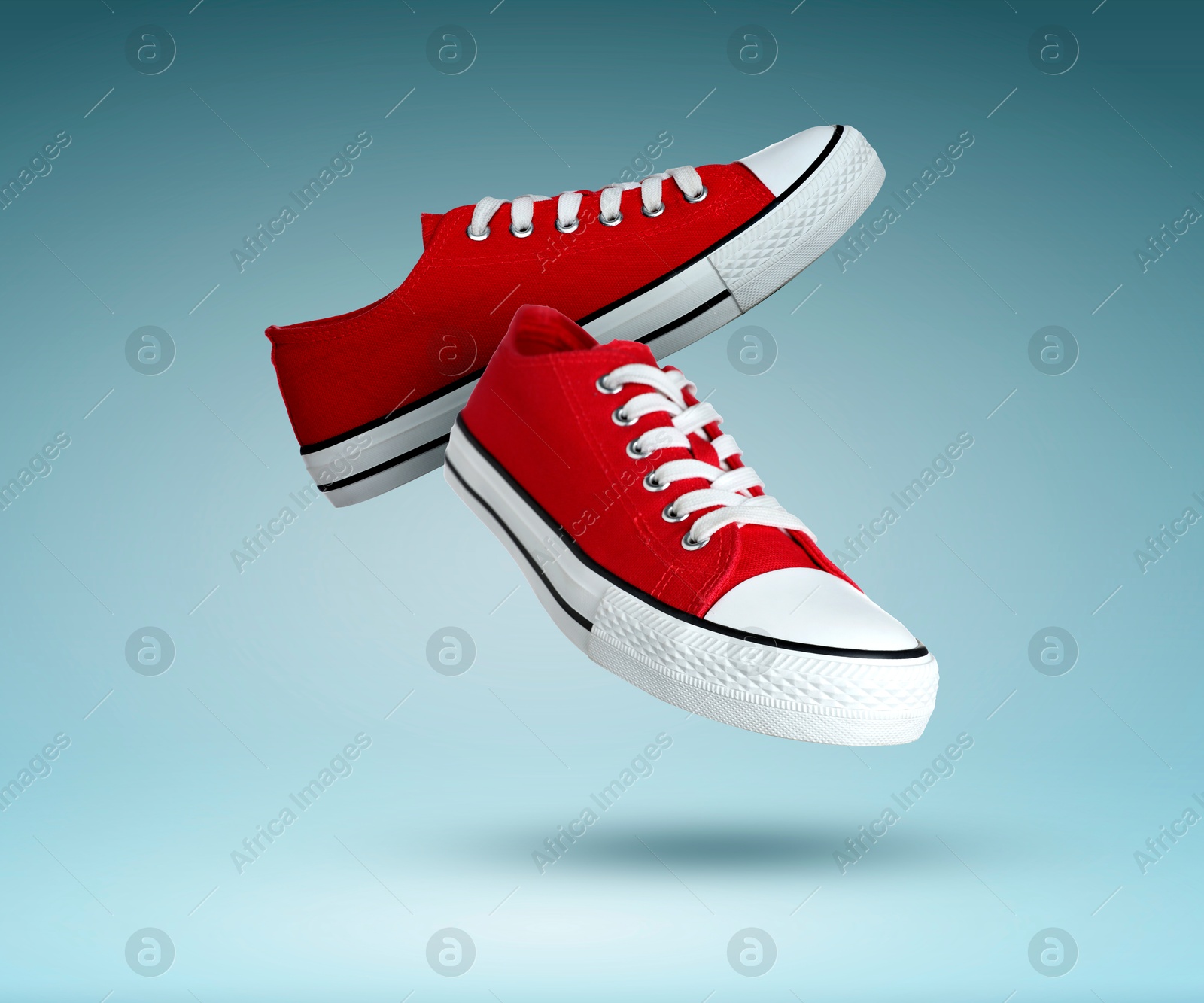 Trendy red sneakers in air on teal gradient background Image of Trendy red sneakers in air on teal gradient background