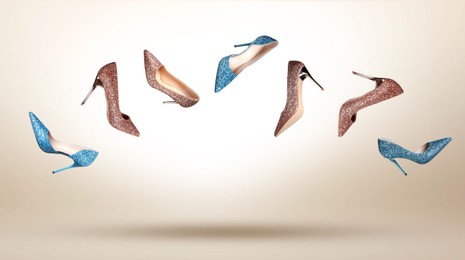 Image of Stylish sparkly high heel shoes in air on beige gradient background