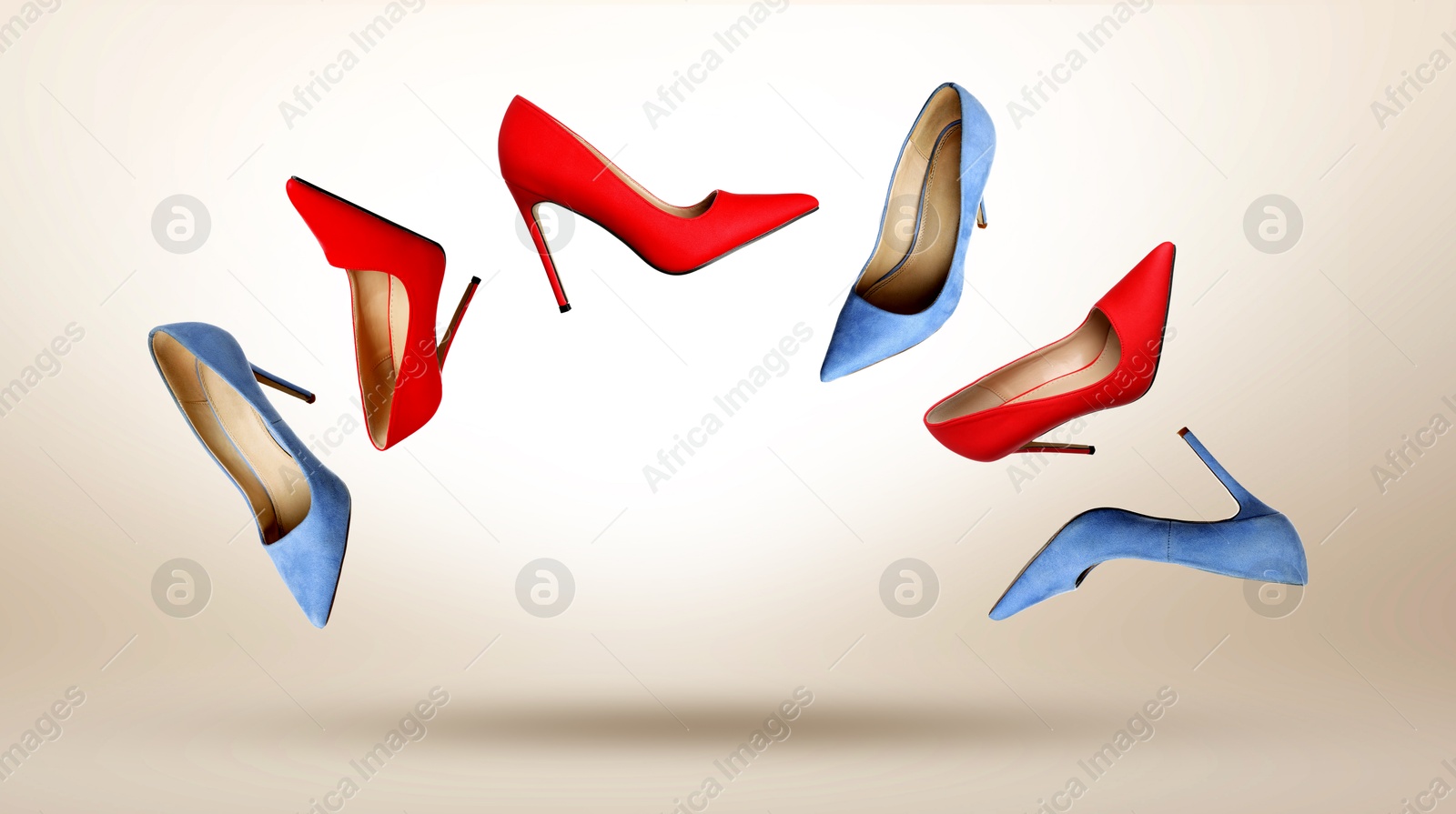 Different fashionable high heeled shoes in air on beige gradient background Image of Different fashionable high heeled shoes in air on beige gradient background