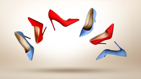 Image of Different fashionable high heeled shoes in air on beige gradient background
