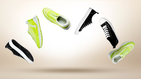 Image of Different trendy sneakers in air on beige gradient background