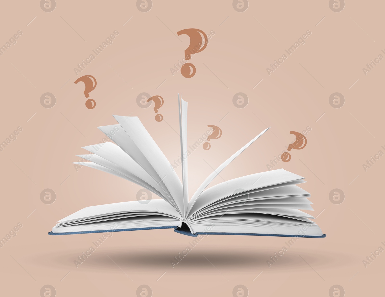 Question marks above open book in air against dusty pink background Image of Question marks above open book in air against dusty pink background