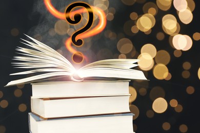 Image of Question mark above open book against black background with blurred lights