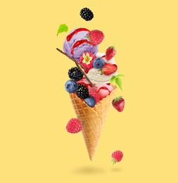 Image of Yummy ice cream balls, wafer cone and berries in air on golden background
